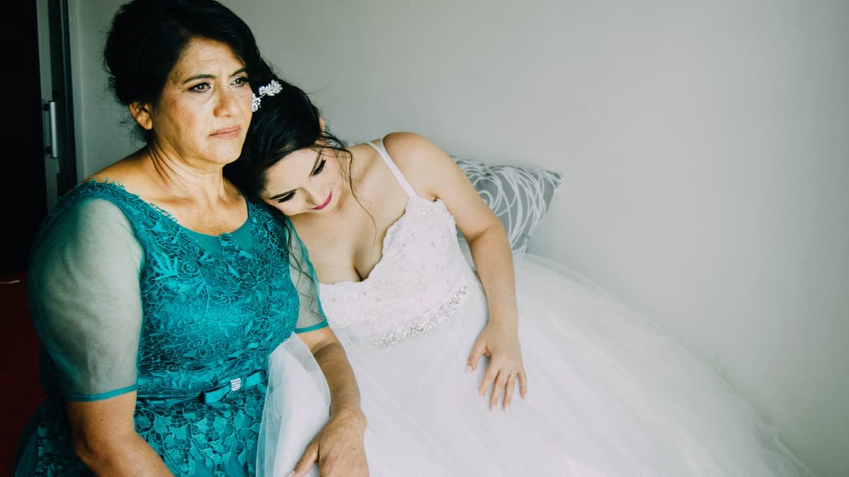 A bride shares a tender moment with her mother before the wedding ceremony.